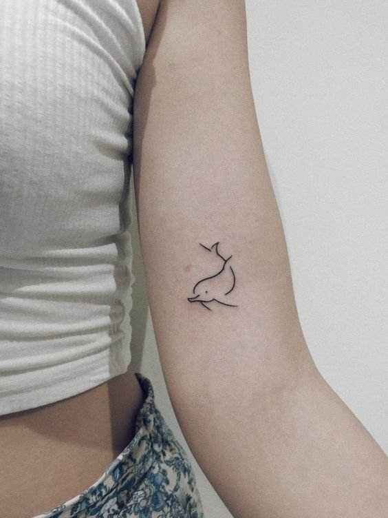Hình xăm cá heo tối giản trên tay, phong cách blackwork, độ phân giải HD.