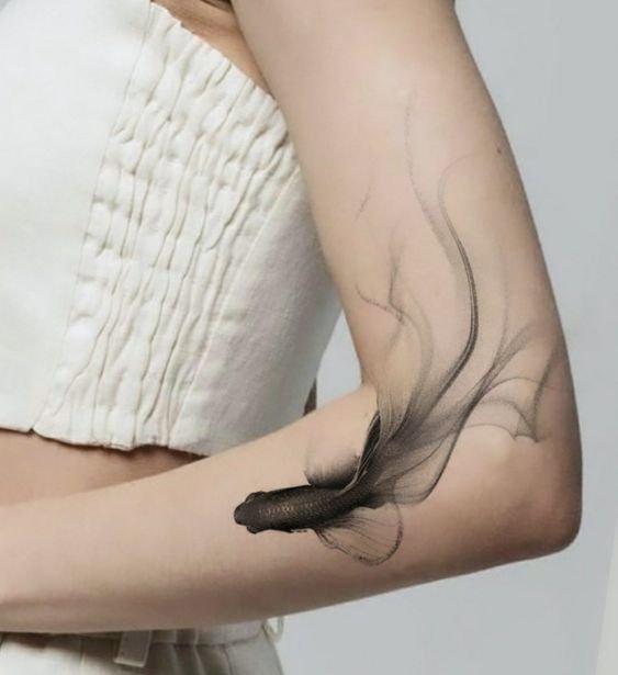 Hình xăm cá phong cách blackwork trên cánh tay, chi tiết tinh tế, ảnh chất lượng cao.