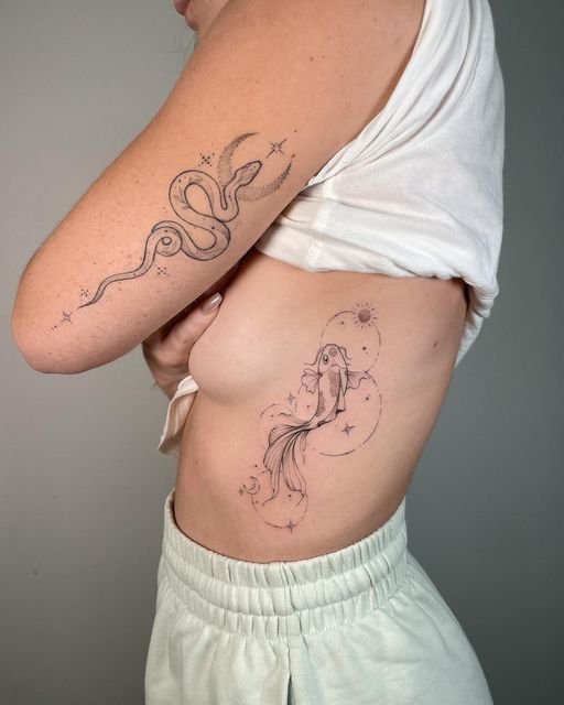 Hình xăm cá và rắn phong cách blackwork trên tay và mạn sườn, chi tiết tinh tế, ảnh chất lượng HD.