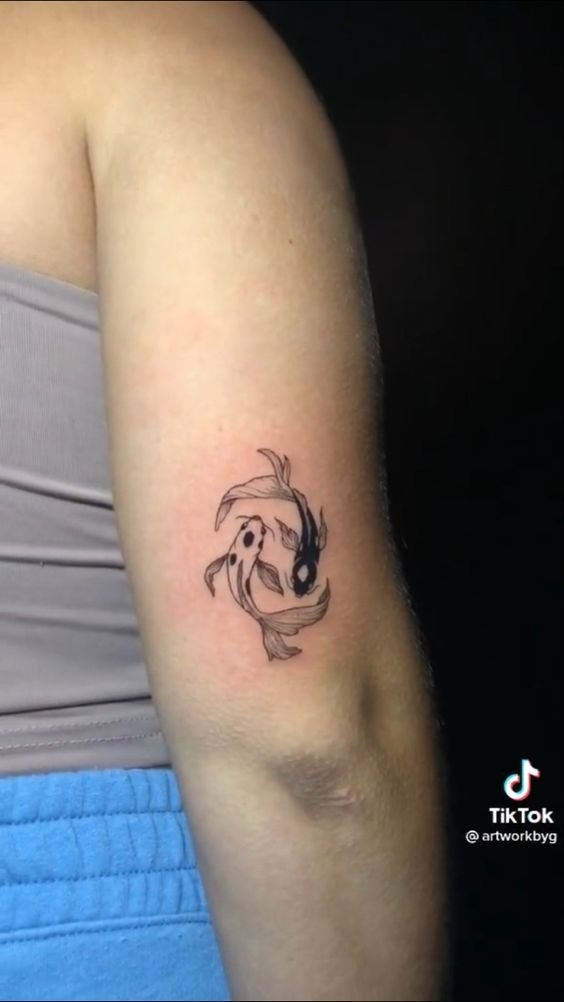 Hình xăm cá koi mini trên bắp tay, phong cách blackwork, chi tiết rõ nét, độ phân giải HD.