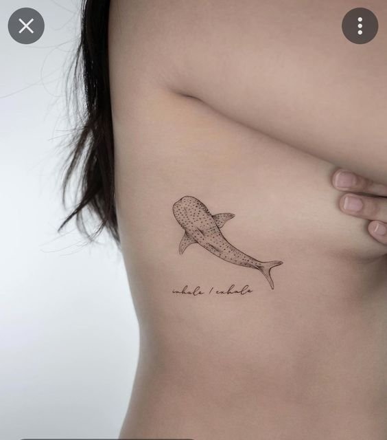 Hình xăm cá voi mini trên sườn, phong cách blackwork, chi tiết rõ nét, độ phân giải HD.