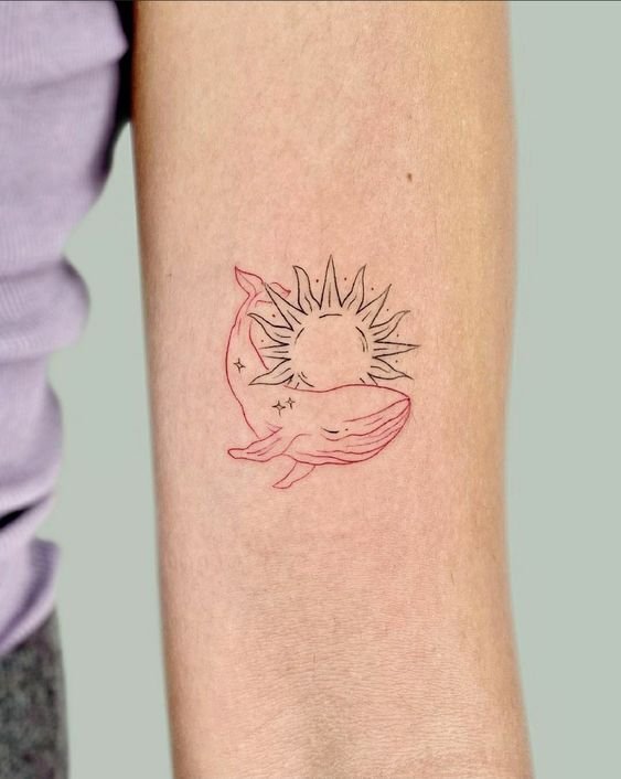 Hình xăm cá voi và mặt trời mini trên bắp tay, phong cách line art, chi tiết rõ nét, ảnh HD.