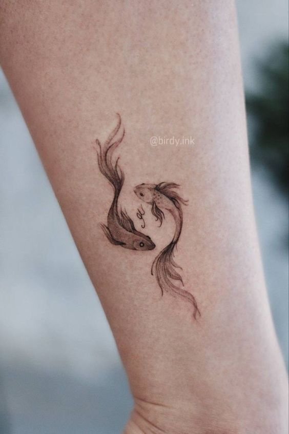 Hình xăm cá chép mini trên cánh tay, phong cách blackwork, chi tiết tinh xảo, ảnh HD.