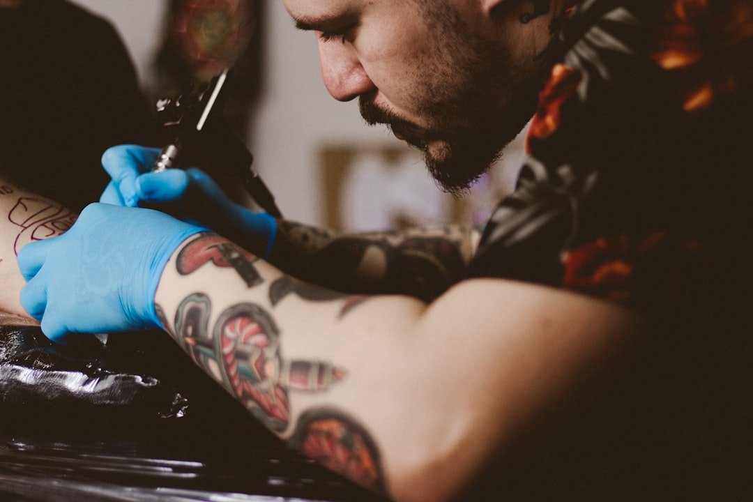 services-01 man-doing-tattoo-on-persons-arm-vkic4k6dm10