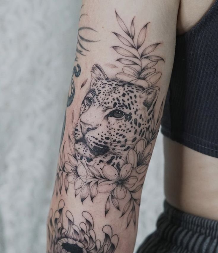 Hình xăm báo hoa mai trên tay, phong cách blackwork, chi tiết cao, độ phân giải HD.