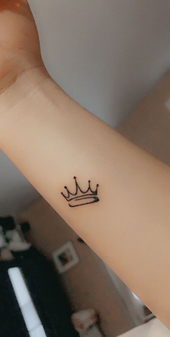 Hình xăm vương miện mini trên cổ tay, phong cách blackwork, độ phân giải HD.