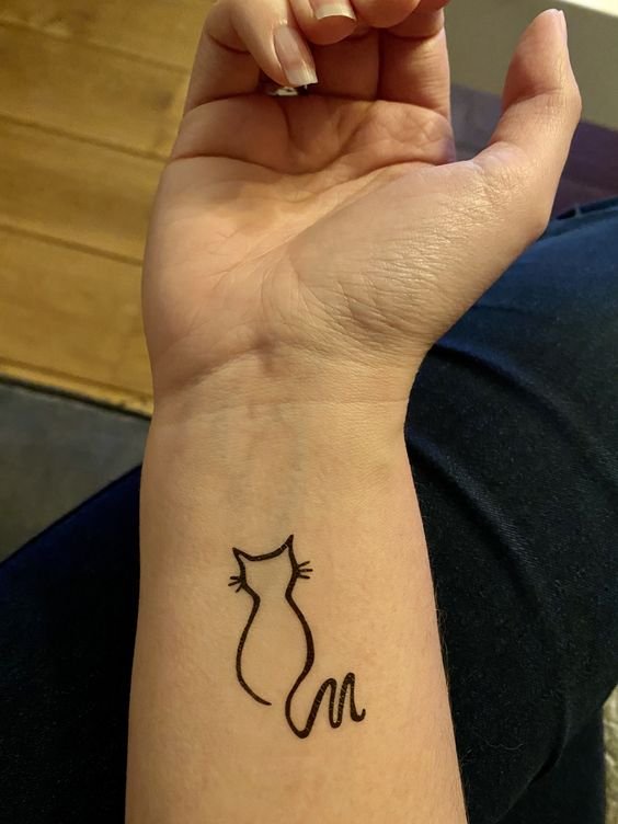 Hình xăm mèo tối giản trên cổ tay, phong cách blackwork, chi tiết rõ nét, ảnh độ phân giải HD.