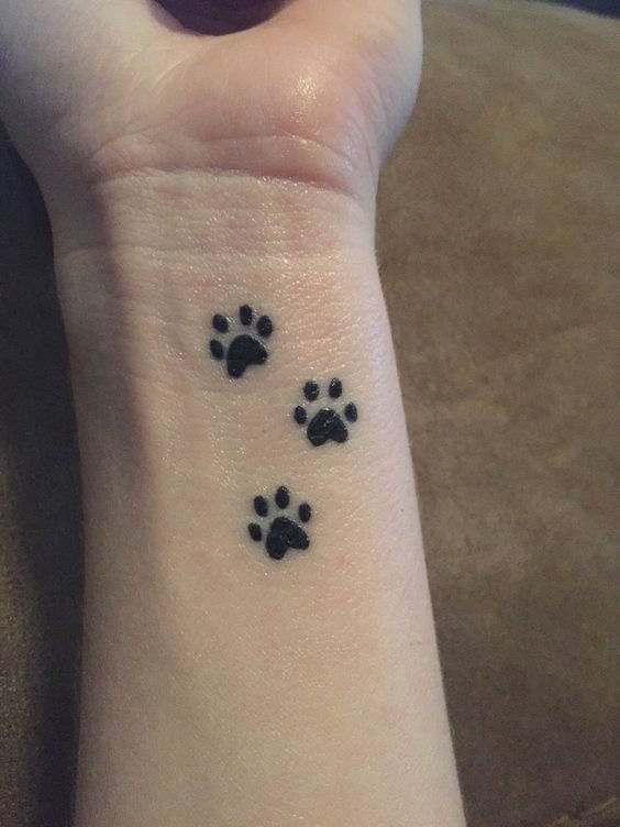 Hình xăm dấu chân động vật trên cổ tay, phong cách blackwork, chi tiết rõ nét, độ phân giải HD.