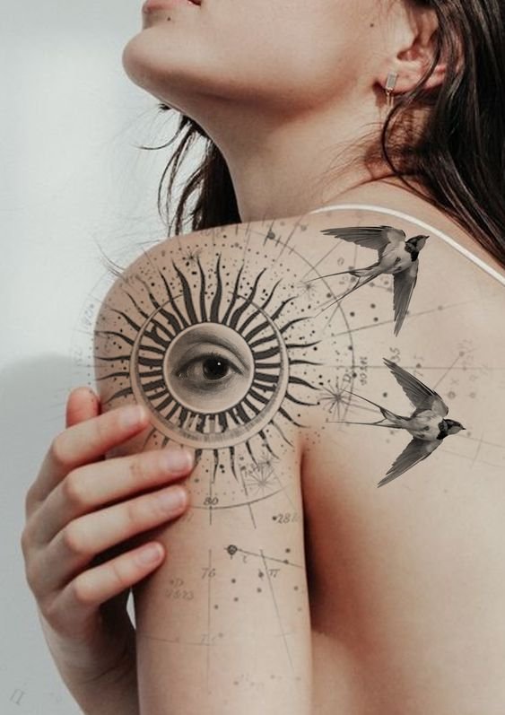 Hình xăm mắt và chim trên vai, phong cách blackwork chi tiết. Ảnh độ phân giải cao.