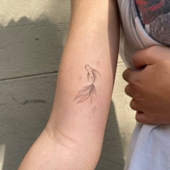 Hình xăm cá mini trên tay, phong cách blackwork tinh tế, độ phân giải HD.