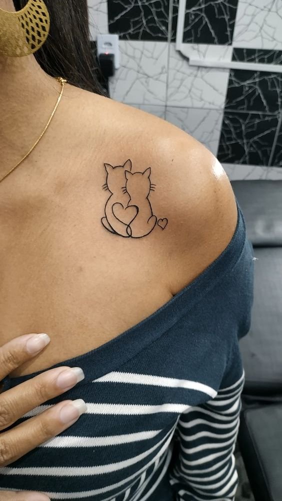 Hình xăm hai chú mèo nhỏ trên vai, phong cách tối giản, chi tiết nhẹ, độ phân giải HD.