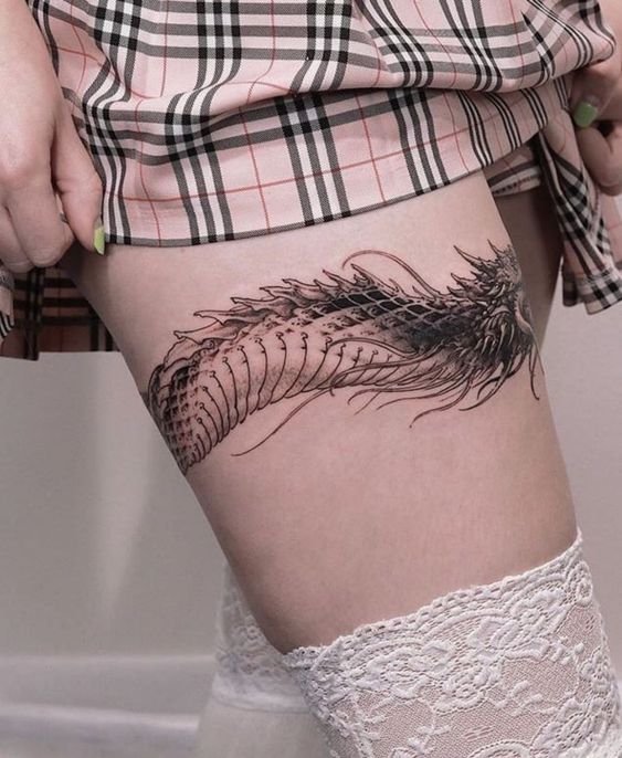 Hình xăm rồng đen trắng trên đùi, phong cách blackwork, chi tiết rõ nét, chất lượng HD.