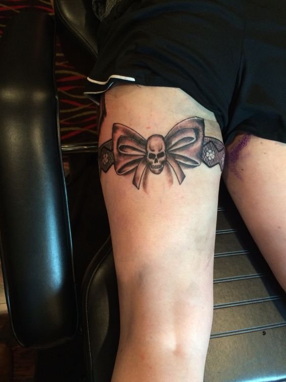 Hình xăm nơ sọ trên đùi, phong cách blackwork chi tiết, độ phân giải HD.