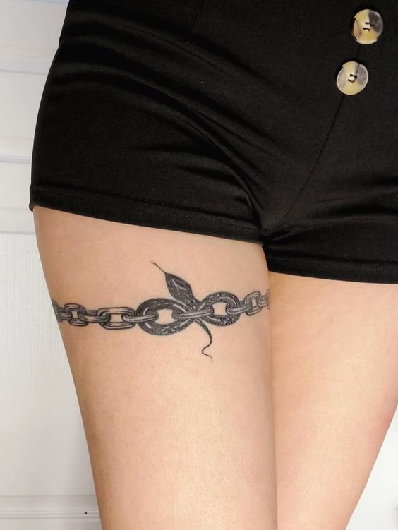 Hình xăm chuỗi và rắn phong cách blackwork trên đùi, độ chi tiết cao, chất lượng HD.
