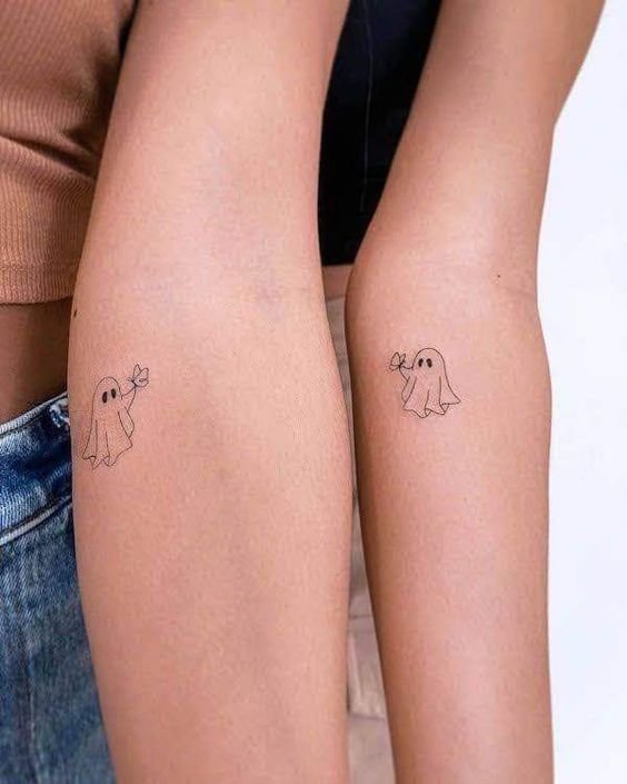 Hình xăm ma mini trên cánh tay, phong cách tối giản, chi tiết rõ nét, độ phân giải HD.