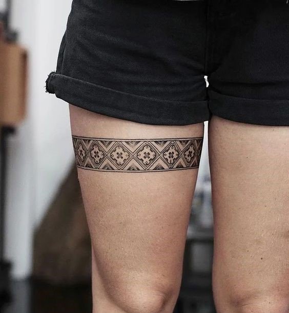 Hình xăm họa tiết hình học trên đùi, phong cách blackwork, chi tiết rõ nét, độ phân giải HD.