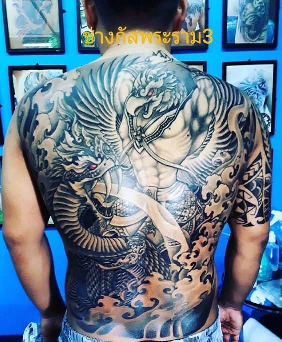 hình xăm kim sí điểu chiến đấu với mãng xà kín lưng Hình xăm rồng lớn phong cách blackwork trên lưng, chi tiết cao, độ phân giải HD.