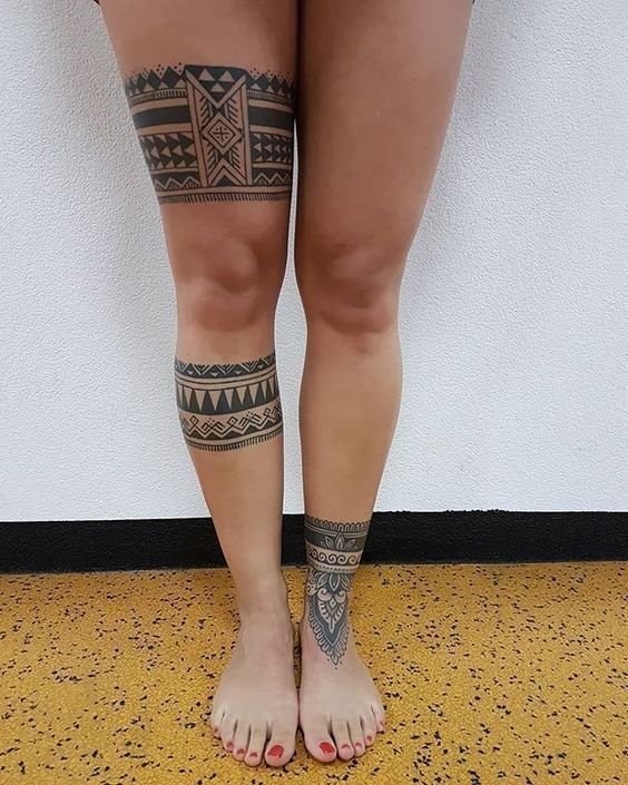 Hình xăm họa tiết bộ lạc trên đùi và chân, phong cách blackwork, chi tiết sắc nét, độ phân giải HD.
