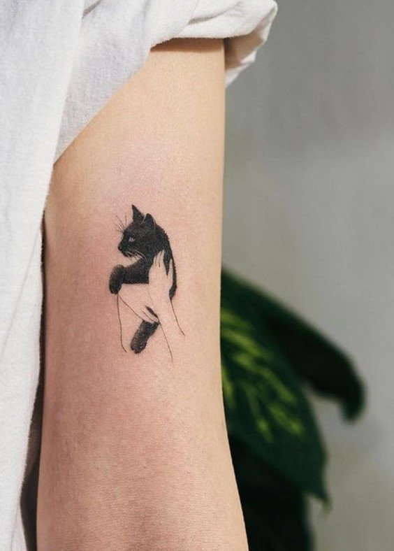 Hình xăm mèo mini trên cánh tay, phong cách blackwork, chi tiết rõ ràng, độ phân giải HD.