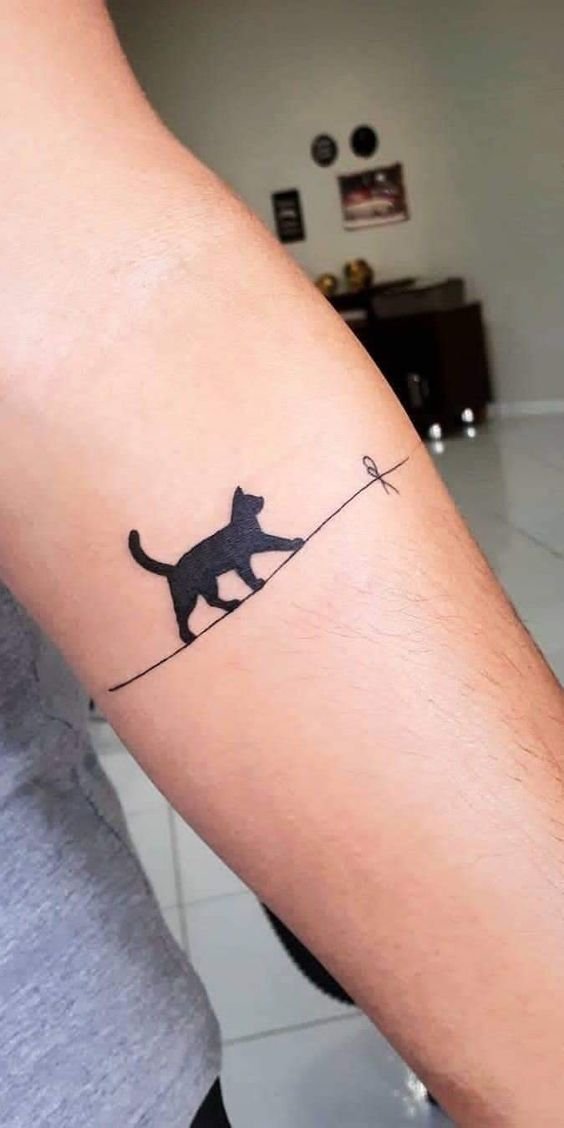 Hình xăm mèo mini phong cách blackwork trên cánh tay, chi tiết tinh tế, ảnh độ phân giải cao.