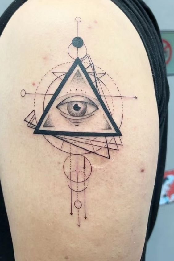 Hình xăm mắt với họa tiết hình học trên bắp tay, phong cách blackwork, chi tiết rõ nét, độ phân giải HD.