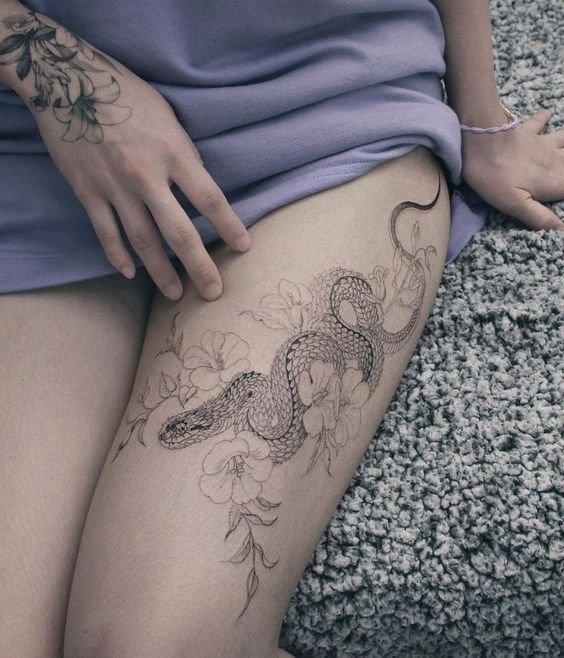 Hình xăm rắn hoa trên đùi, phong cách blackwork chi tiết, ảnh độ phân giải cao.
