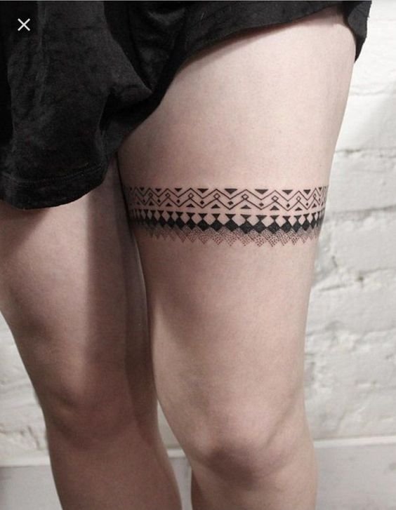 Hình xăm tribal trên đùi, phong cách blackwork, chi tiết rõ nét, độ phân giải HD.