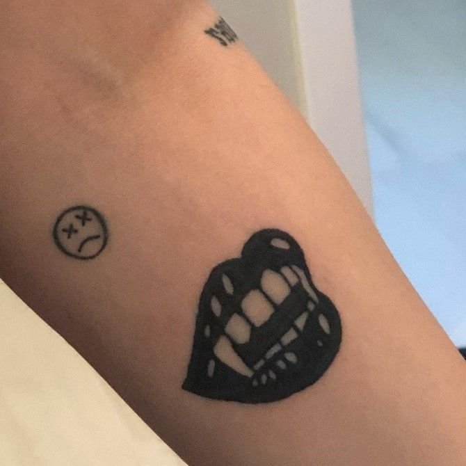 Hình xăm blackwork miệng và mặt buồn trên cánh tay, chi tiết rõ nét, độ phân giải HD.