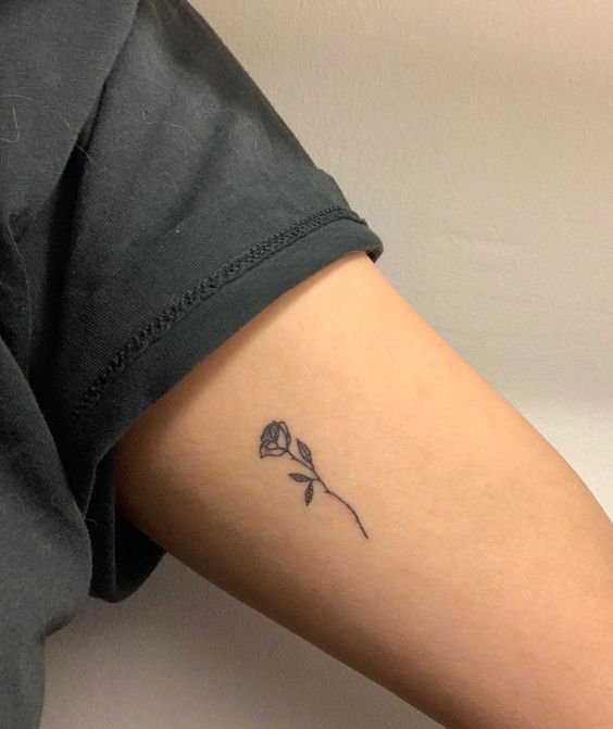 Thiết kế hoa hồng đen mini gọn gàng, hấp dẫn Mini rose tattoo on arm in blackwork style, simple design. High-resolution image, clear details.