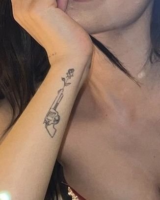 Hoa hồng đen mini kết hợp cùng súng lạ mắt Hình xăm súng và hoa trên cánh tay, phong cách blackwork, chi tiết rõ nét, ảnh HD.