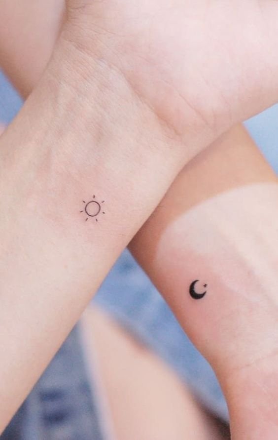 Hình xăm mini mặt trời và mặt trăng trên cổ tay, phong cách blackwork, ảnh độ phân giải HD.