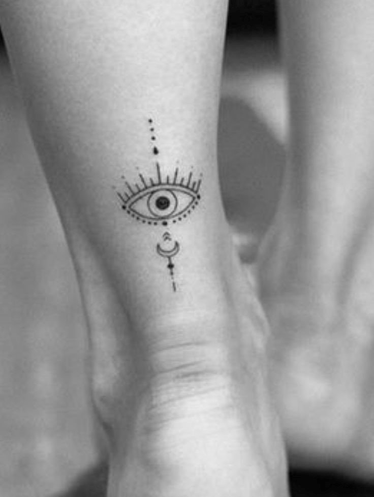 Hình xăm con mắt trên mắt cá chân, phong cách blackwork chi tiết, ảnh đen trắng HD.